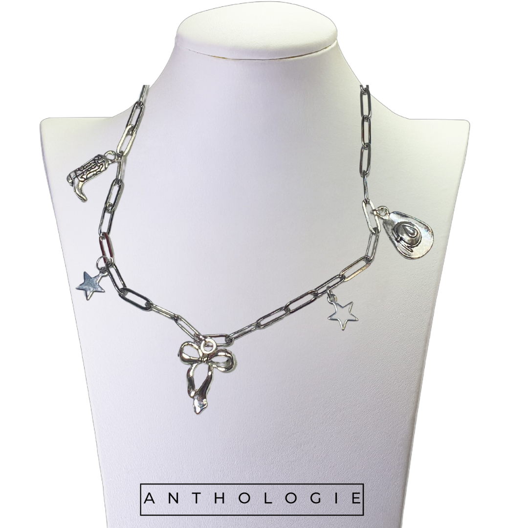 Silver chain necklace with charms on a mannequin bust labeled 'Anthologie'.