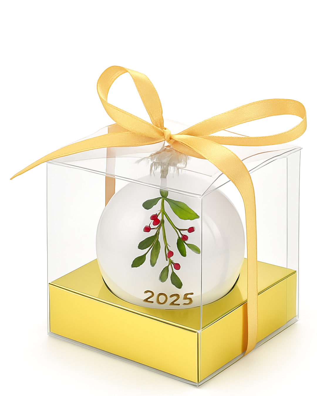 Christmas ornament with mistletoe design and '2025' in a clear box with a yellow ribbon on a white background.